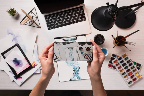 Designer workspace with sketches and laptop